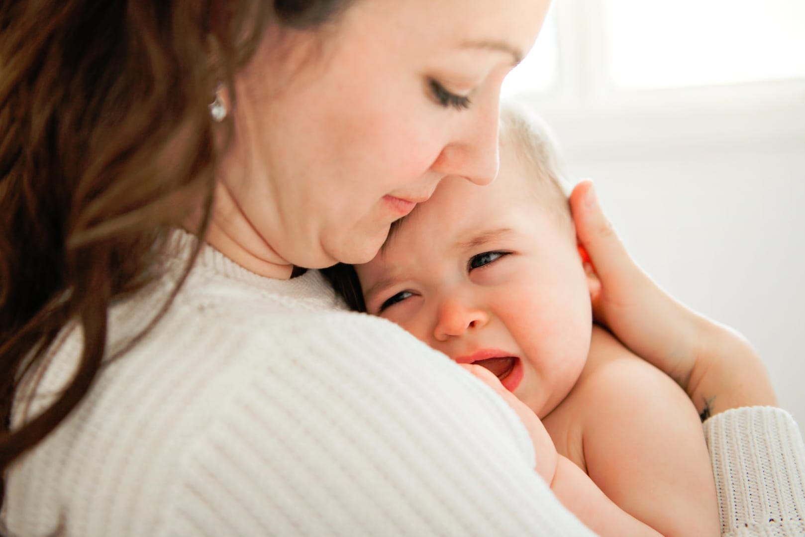 Eine Mutter tröstet ihr Baby. Eine Mutter tröstet ihr Baby.