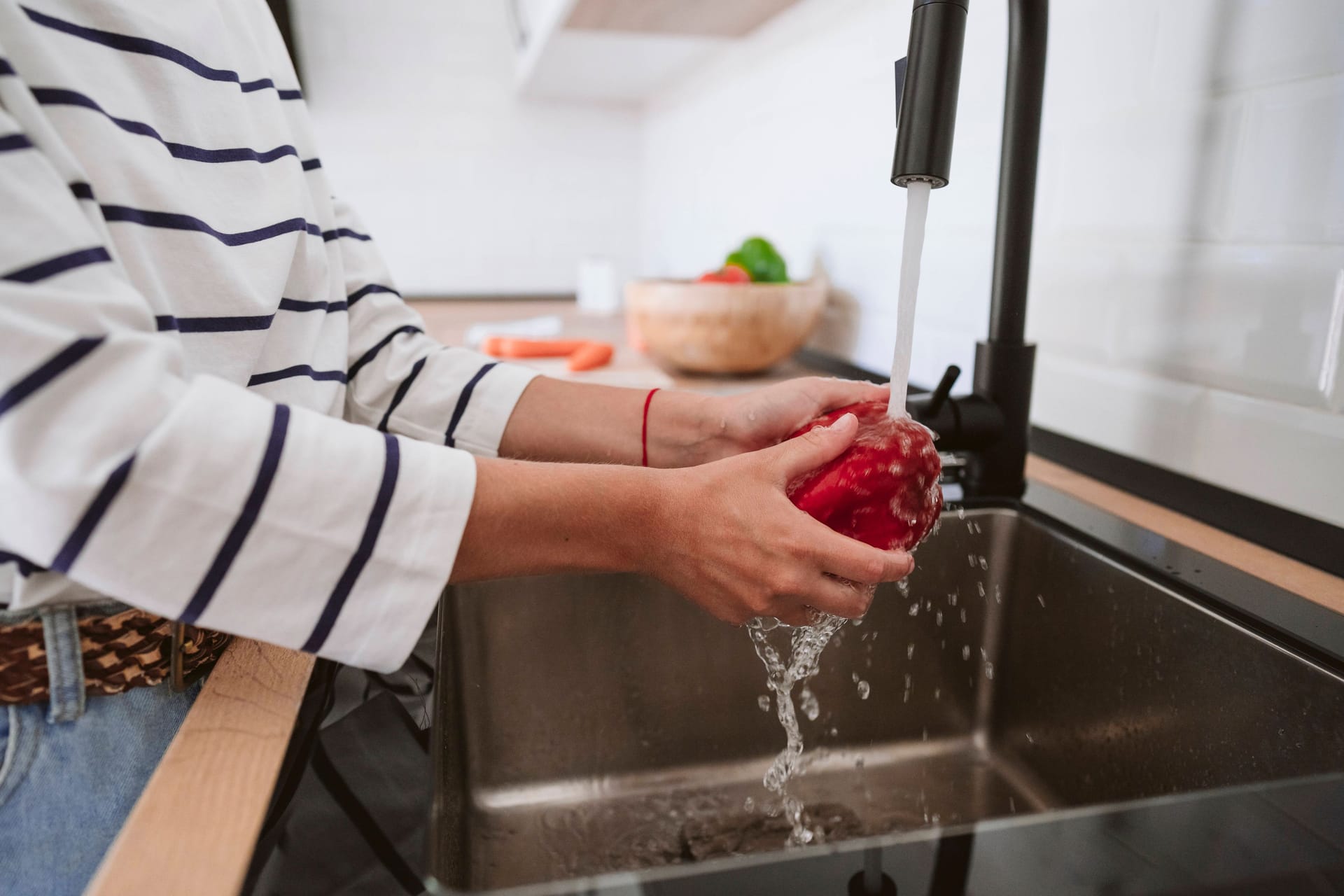 Eine Frau wäscht Gemüse (Symbolbild): 700 Haushalte bei Hannover müssen seit über einer Woche auf Trinkwasser aus der Leitung verzichten. Eine Frau wäscht Gemüse (Symbolbild): 700 Haushalte bei Hannover müssen seit über einer Woche auf Trinkwasser aus der Leitung verzichten.