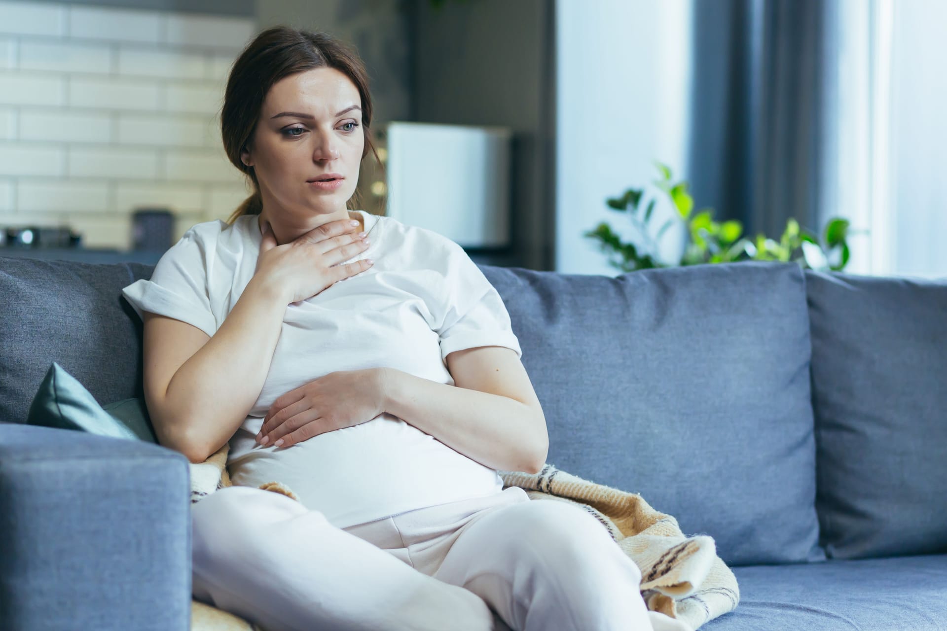 Schwangere mit Übelkeit auf Couch Schwangere mit Übelkeit auf Couch