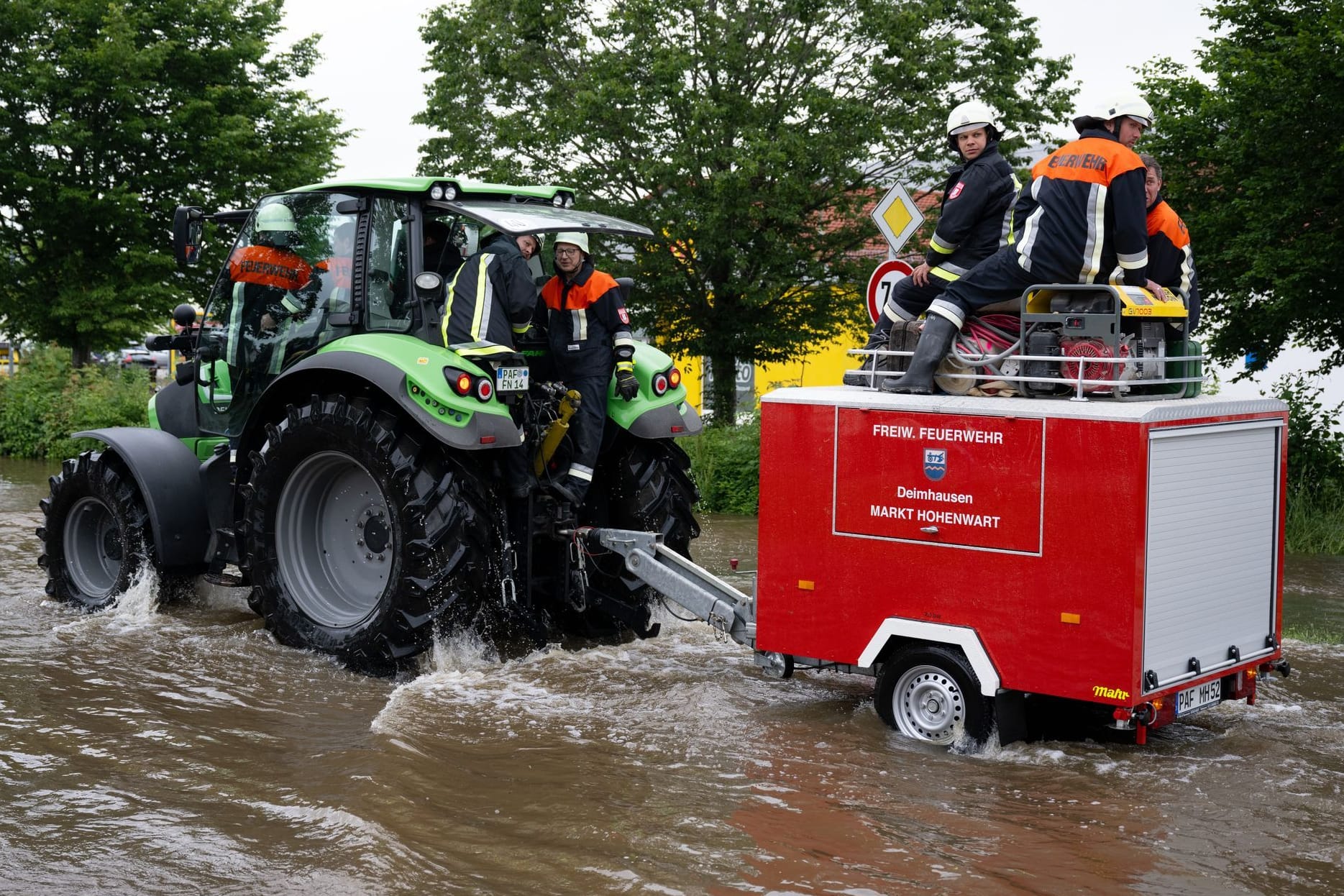 Bayern, Reichertshofen: Feuerwehrleute wissen sich zu helfen und fahren mit einem Feuerwehr-Traktor durch das Hochwasser. Bayern, Reichertshofen: Feuerwehrleute wissen sich zu helfen und fahren mit einem Feuerwehr-Traktor durch das Hochwasser.
