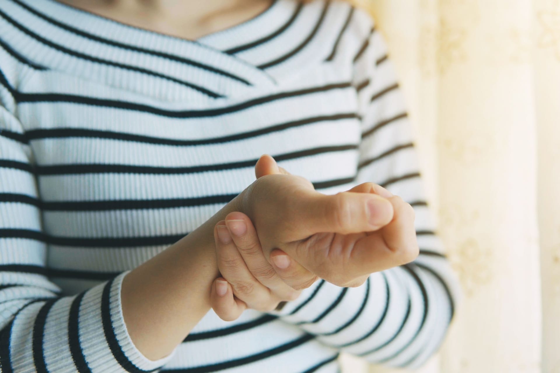 Frau mit Handbeschwerden: Ein Schnappfinger am Daumen kann den Alltag beeinträchtigen. Frau mit Handbeschwerden: Ein Schnappfinger am Daumen kann den Alltag beeinträchtigen.